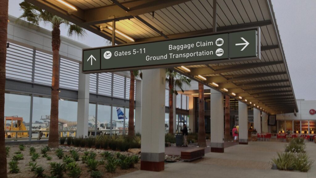Long Beach International Airport signage with directions to Gates 5-11, Baggage Claim and Ground Transportation