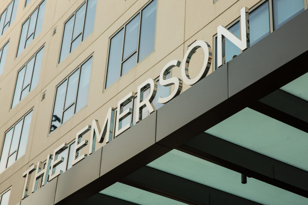 Polished metal letters sit on canopy above the entrance to The Emerson residential building in Downtown LA